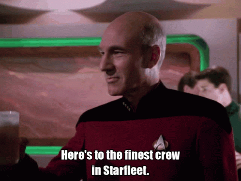 A GIF of captain Picard from Star Trek: The Next Generation, raising his glass to toast and saying 'Here's to the finest crew in Starfleet.'